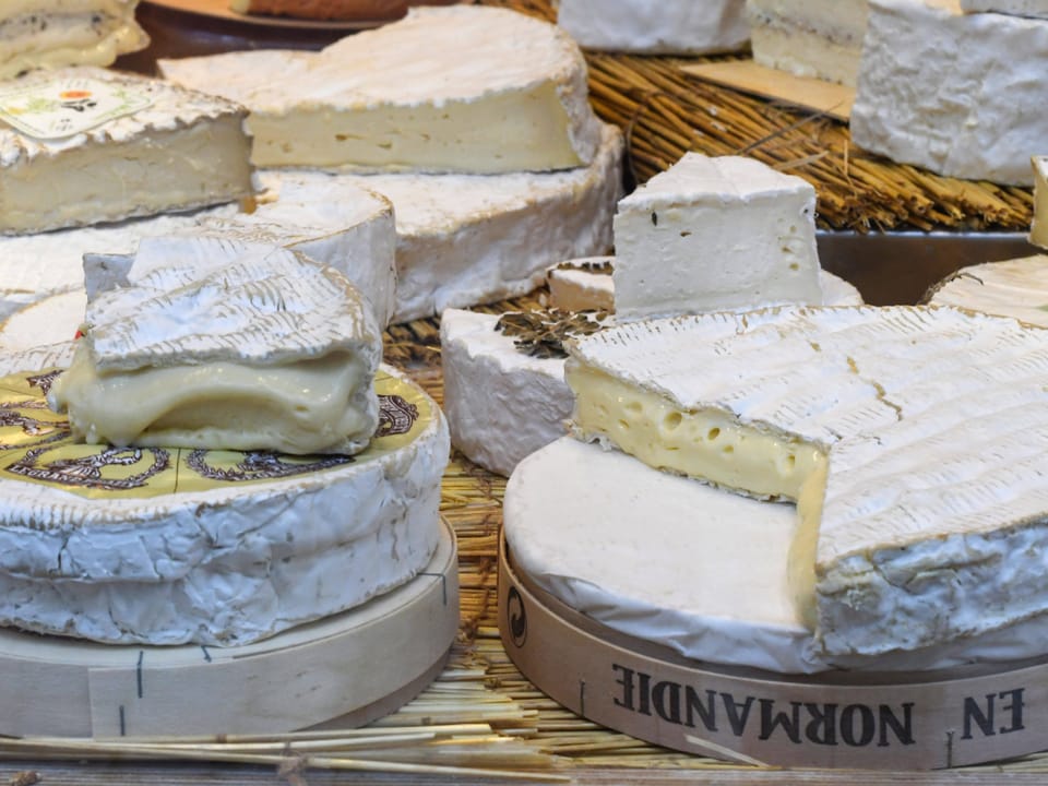 Camembert aus der Normandie und französischer Brie liegen im Schaufenster eines Käse-Delikatessenladens.