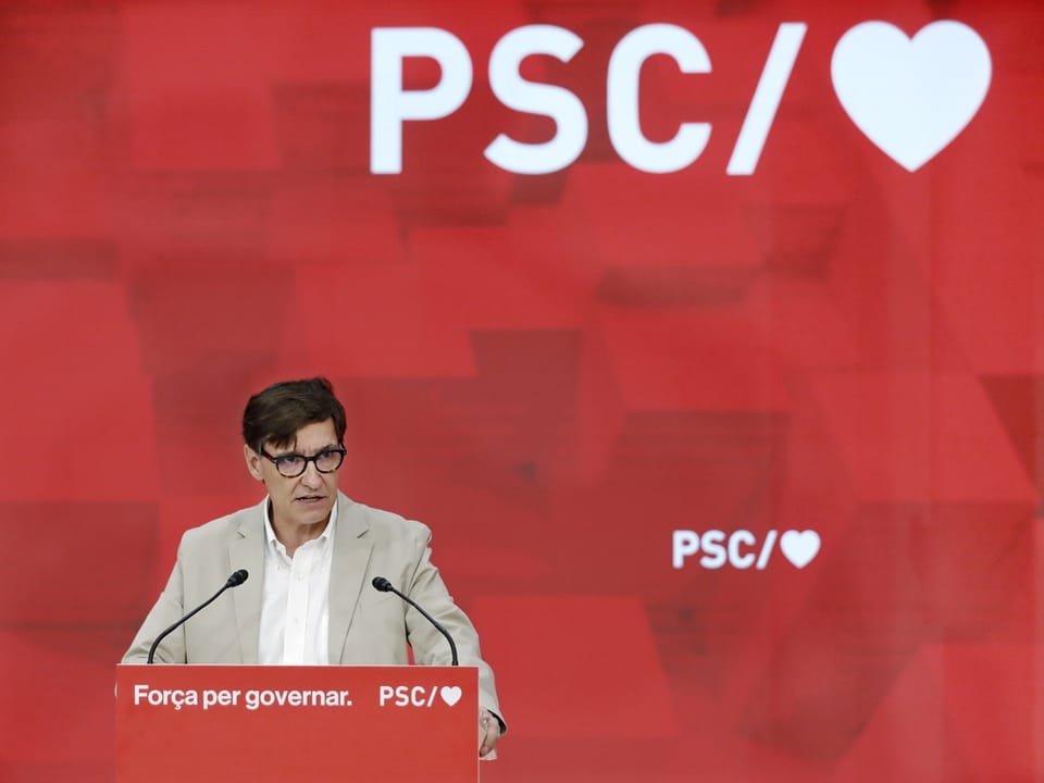 Person hält eine Rede vor einem rot hintergrund mit PSC Logo und Herz.