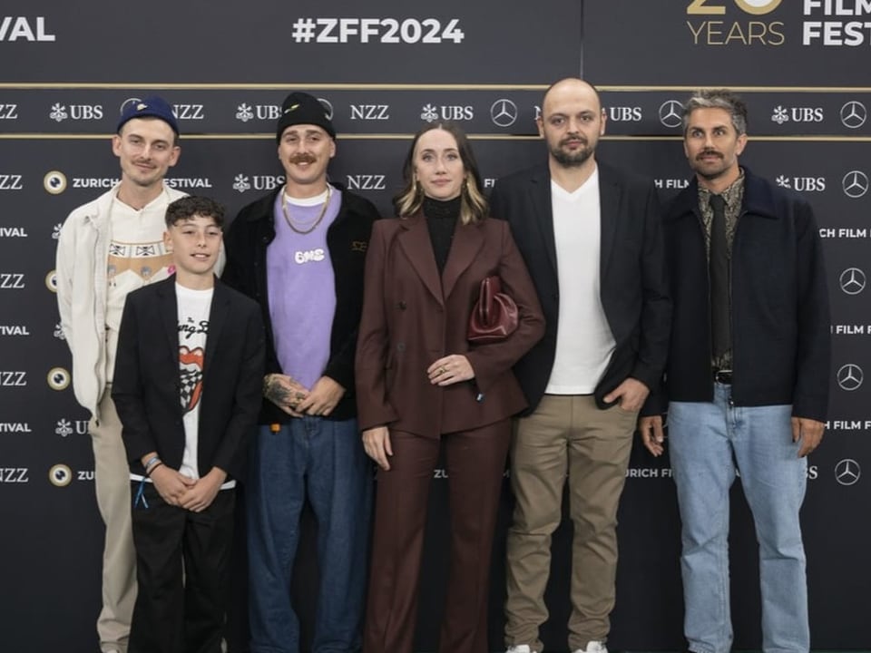 Gruppe von sechs Personen auf dem roten Teppich beim Filmfestival.