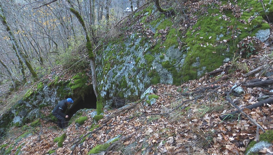 Balzer Spescha davant l’entrada da la tauna.