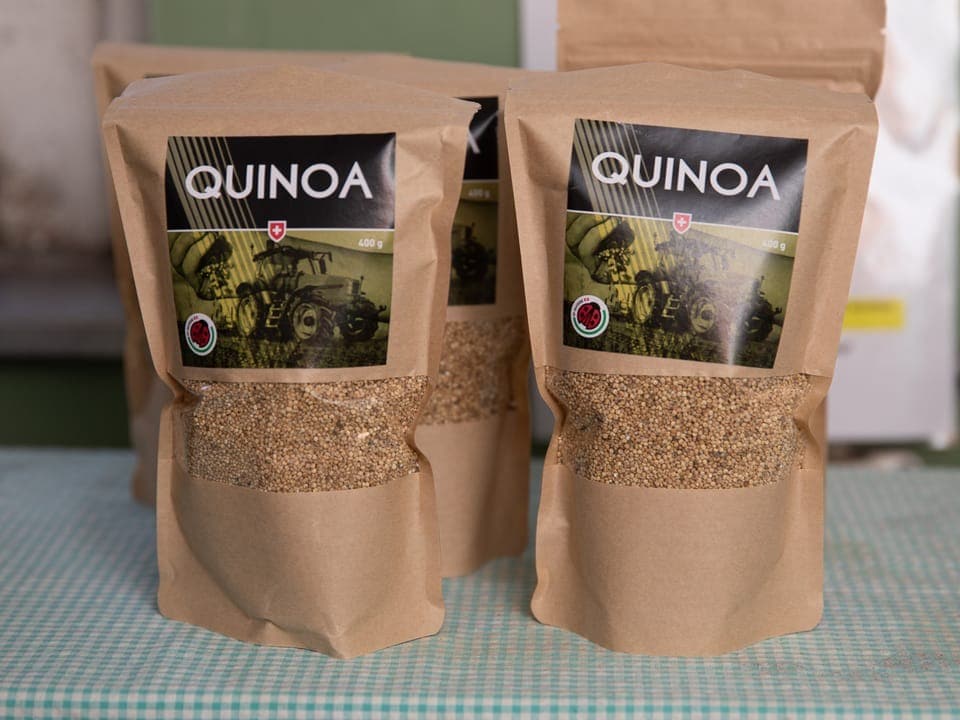 Drei Packungen Quinoa auf einem Tisch.