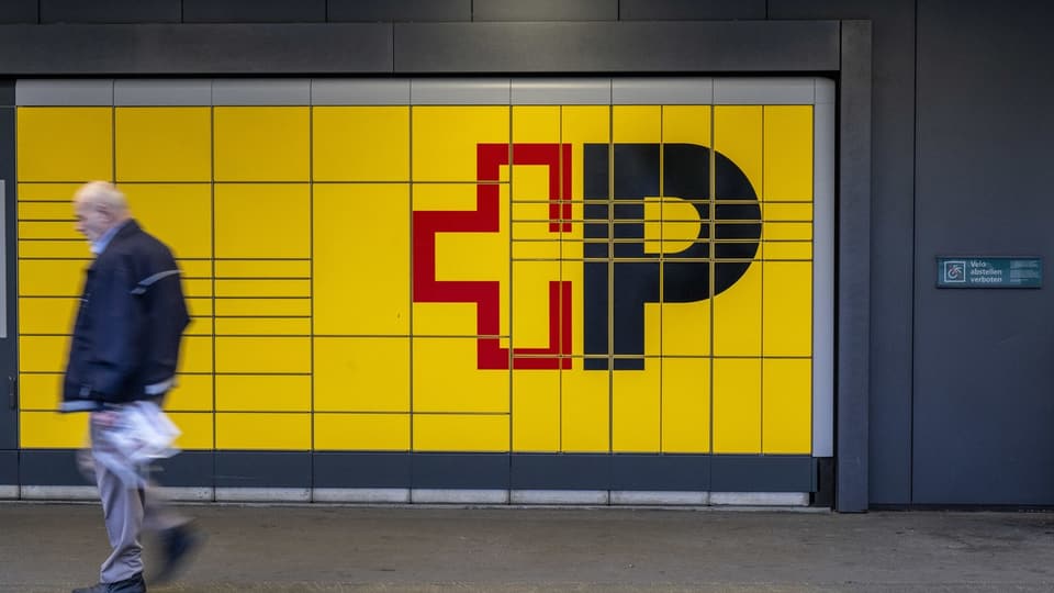 Ein Mann geht an einer gelben Wand mit CP+ Symbolen vorbei.