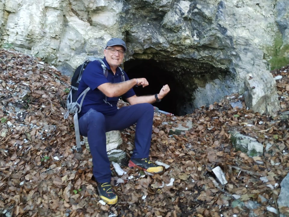 Mann vor Höhle