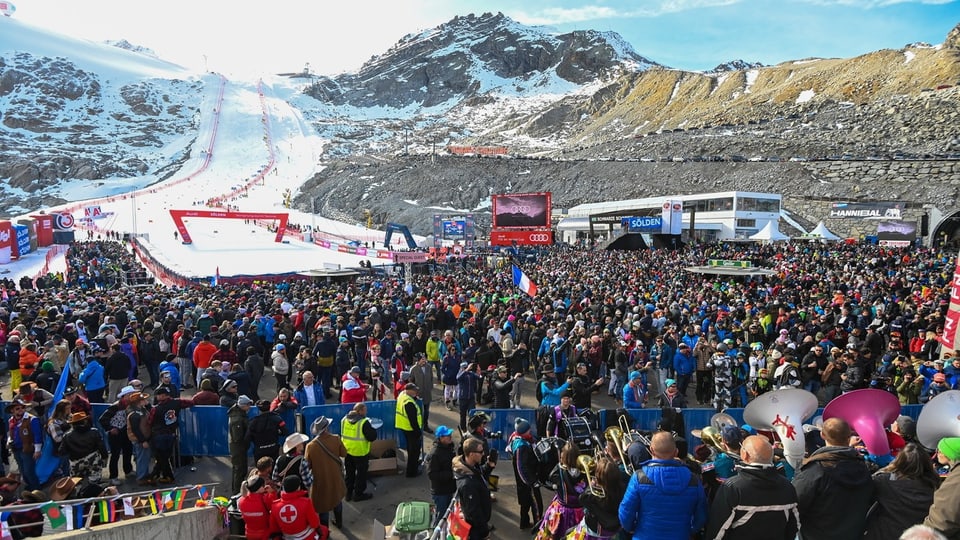 Menschenmenge bei einem Skievent in den Bergen.