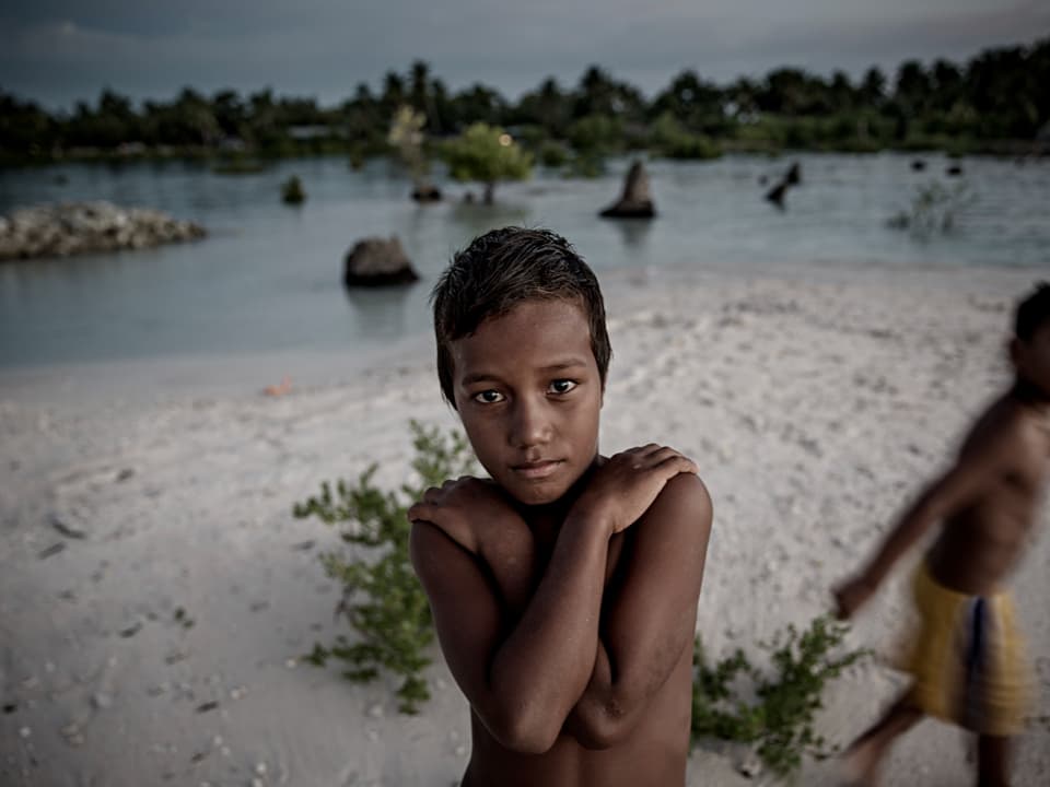 Junge während Flut auf Kiribati