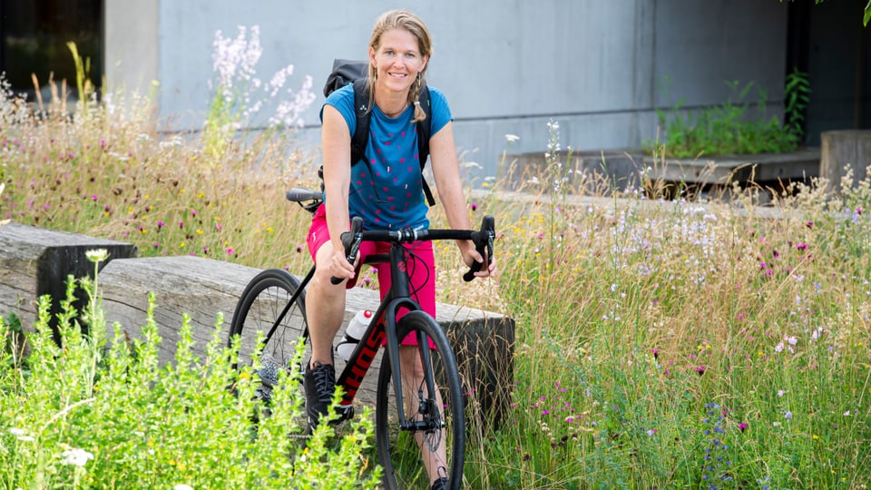 Frau posiert auf Fahrrad.