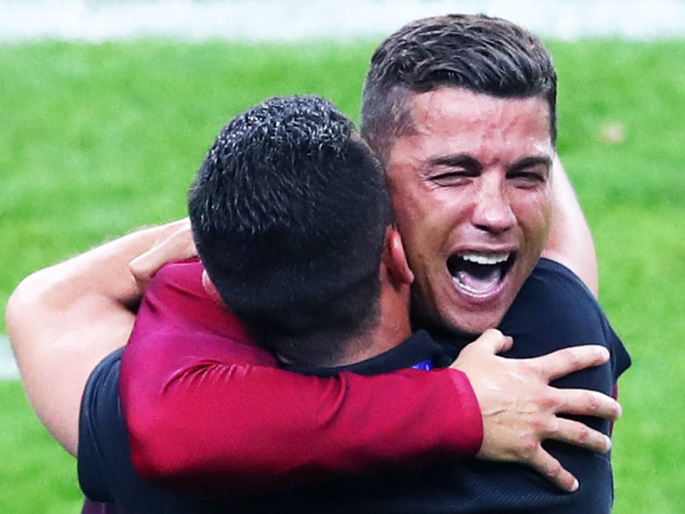 Ronaldo umarmt einen Mann mit geschlossenen Augen und aufgerissenen Mund.