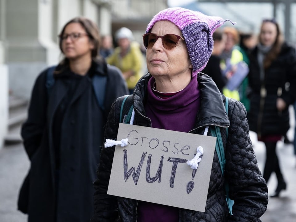 Eine Frau mit einem Plakat nimmt an der Protestaktion in Bern teil. 