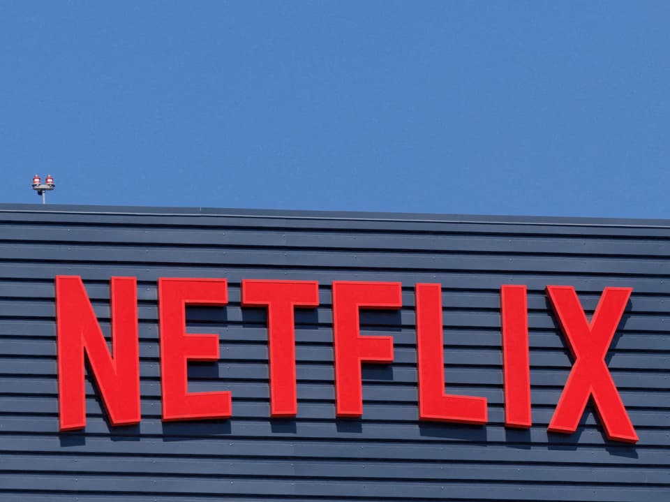 Rotes Netflix-Logo auf blauem Gebäude.