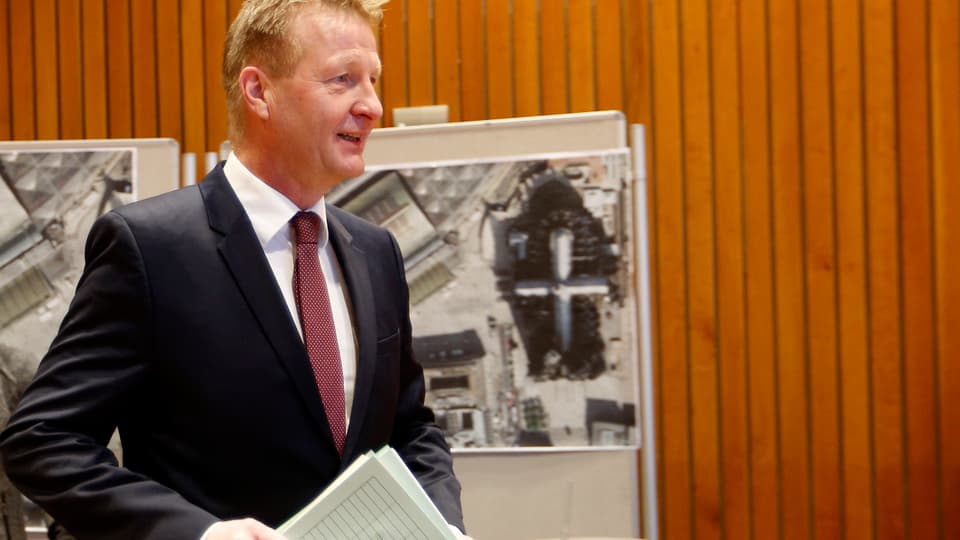 Innenminister Ralf Jäger vor einer Holzwand im Düsseldorfer Landdtag an der Luftaufnahmen hängen