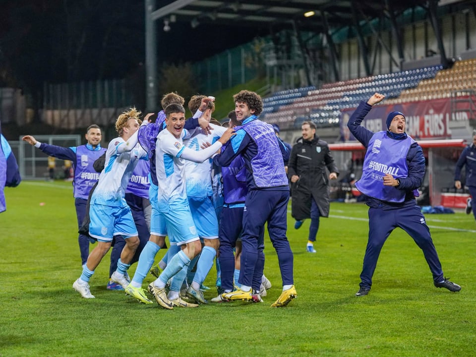 Fussballteam feiert auf dem Spielfeld nach dem Spiel.