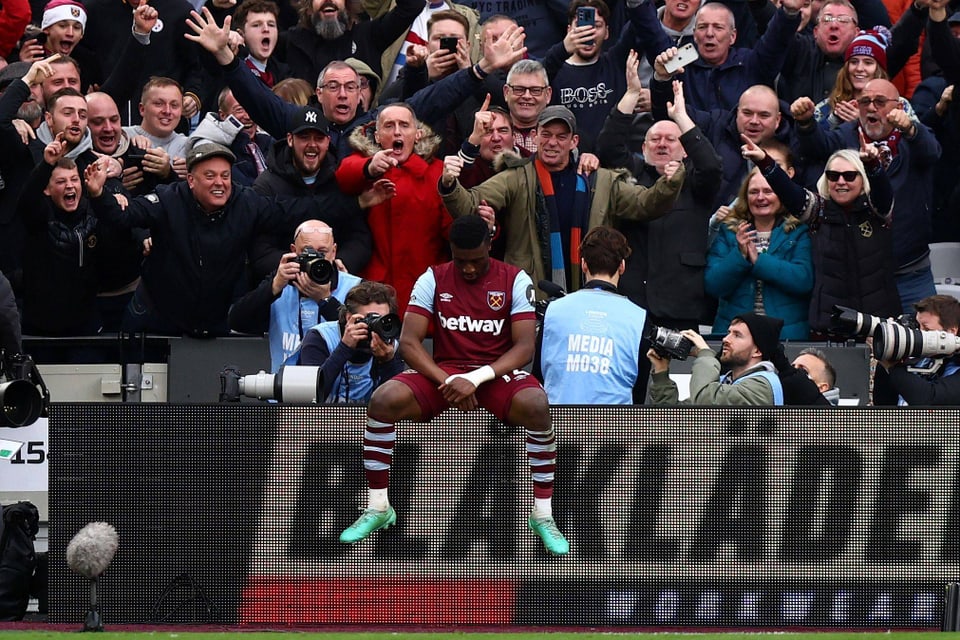 Mohammed Kudus von West Ham United sitzt nach seinem Tor auf der Bande, im Hintergrund jubelnde Fans.