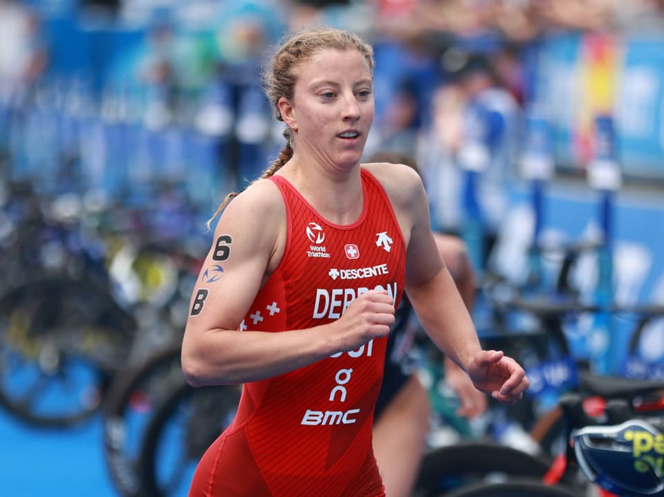 Sportlerin in rotem Trikot läuft bei einem Triathlon.