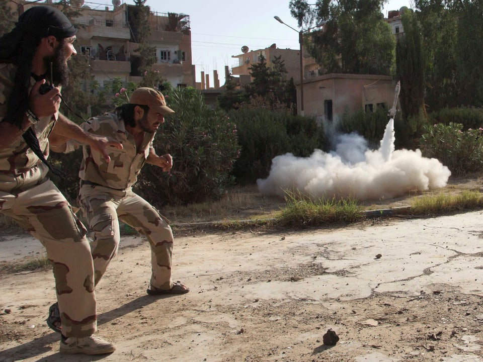 Zwei Kämpfer der Freien Syrischen Armee feuern eine Rakete per Funk ab.