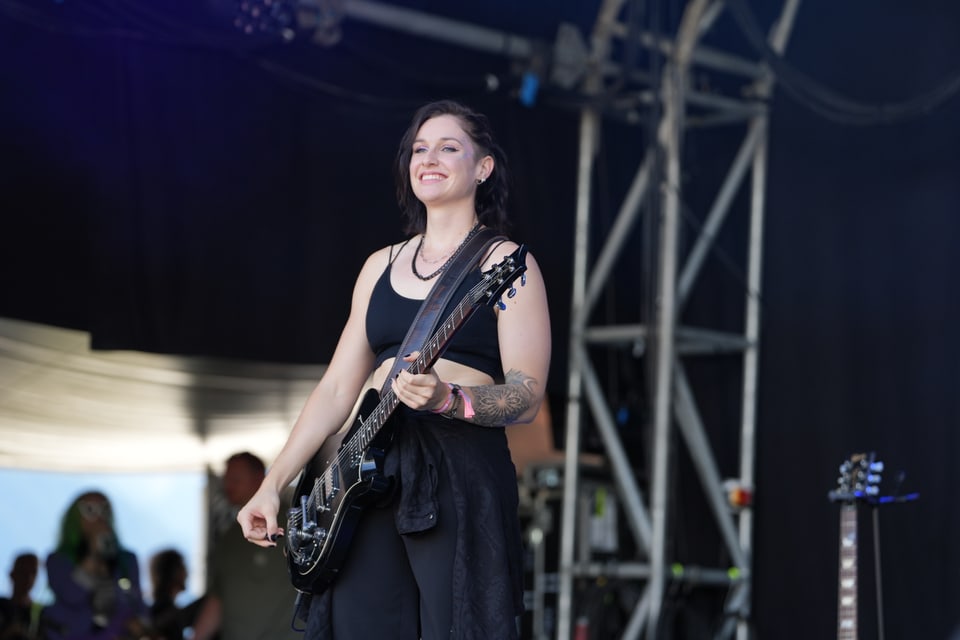 Frau mit Gitarre auf einer Bühne am Open Air Lumnezia 2024.