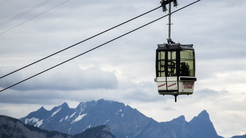 Gondelbahn, im Hintergrund Bergpanorama.