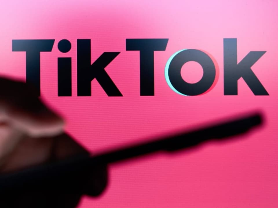 TikTok-Logo auf pinkem Hintergrund mit Smartphone-Silhouette.