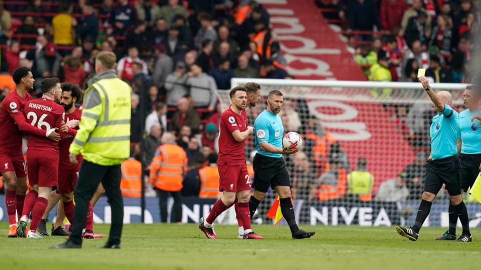 Teamkollegen müssen Robertson zurückhalten, während er vom Schiri Gelb sieht