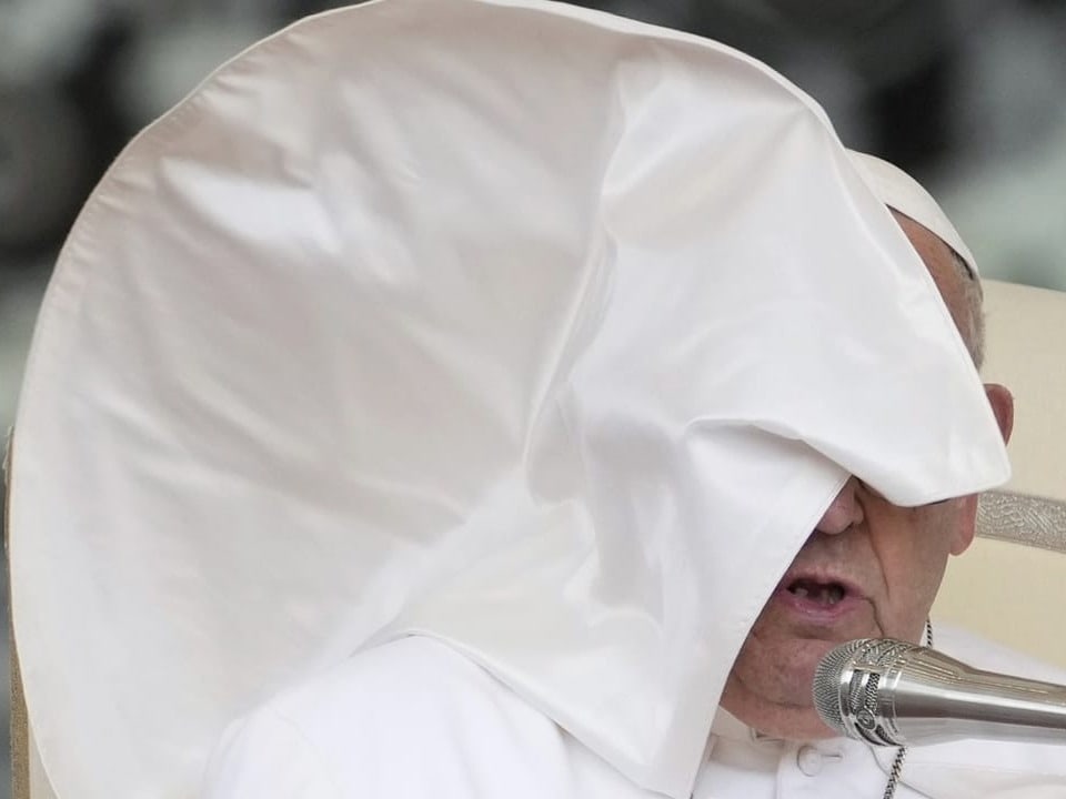 Papst mit verwehter Mitra während einer Ansprache.