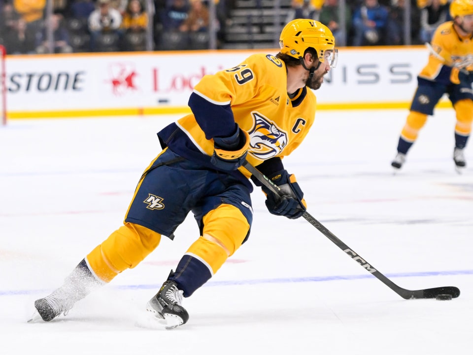 Eishockeyspieler in gelbem Trikot auf dem Eis.