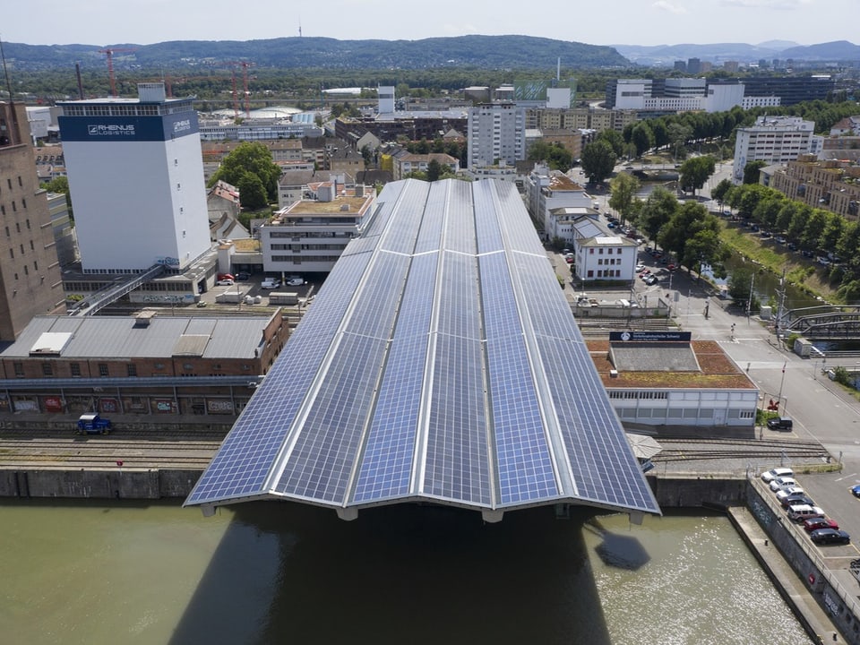 Hafenareal von oben. Man sieht ein riesiges Dach mit Solarzellen.