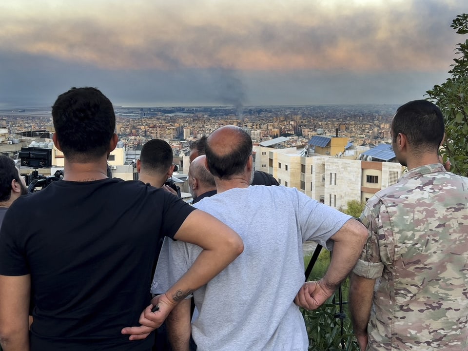 Menschen blicken in den Süden von Beirut, wo israelische Raketen einschlagen.