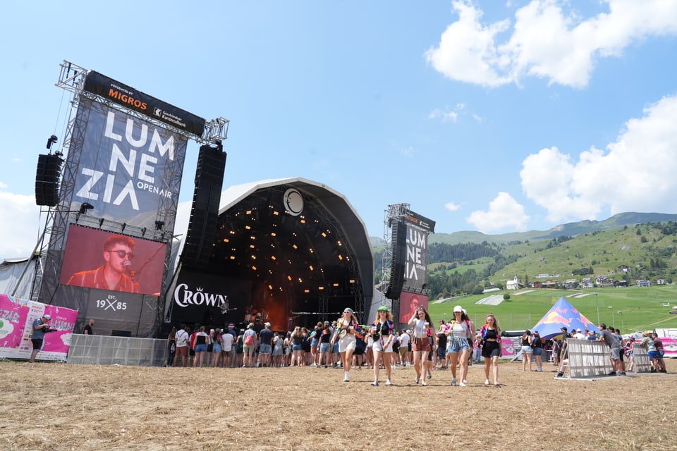 Open Air Lumnezia 2024 mit Bühne und Publikum auf einer Wiese.