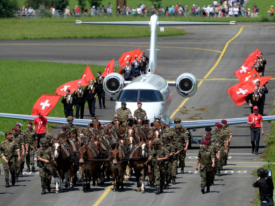 Rösser von der Armee ziehen das Flugzeug