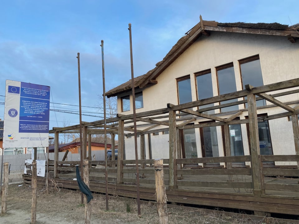 Gebäude mit Holzgerüst und Schildern im Freien.