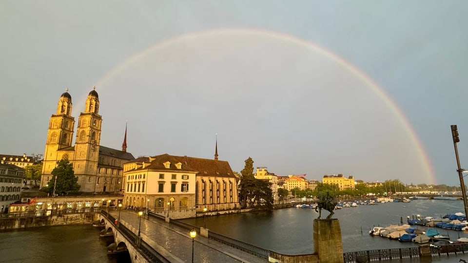 Regenbogen über dem Fluss und historischen Gebäuden in Zürich.