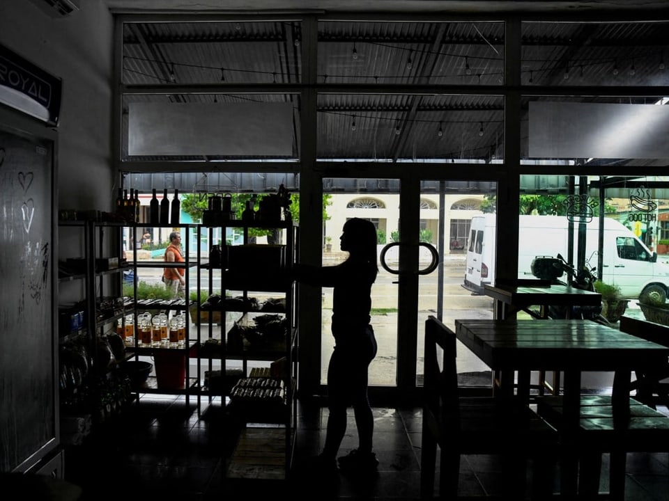 Silhouette einer Person in einem Café mit Glaswand im Hintergrund.