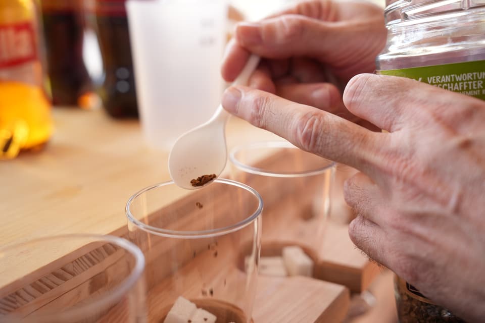 Hand, die Kaffee in einen Messbecher löffelt am Open Air Lumnezia 2024.