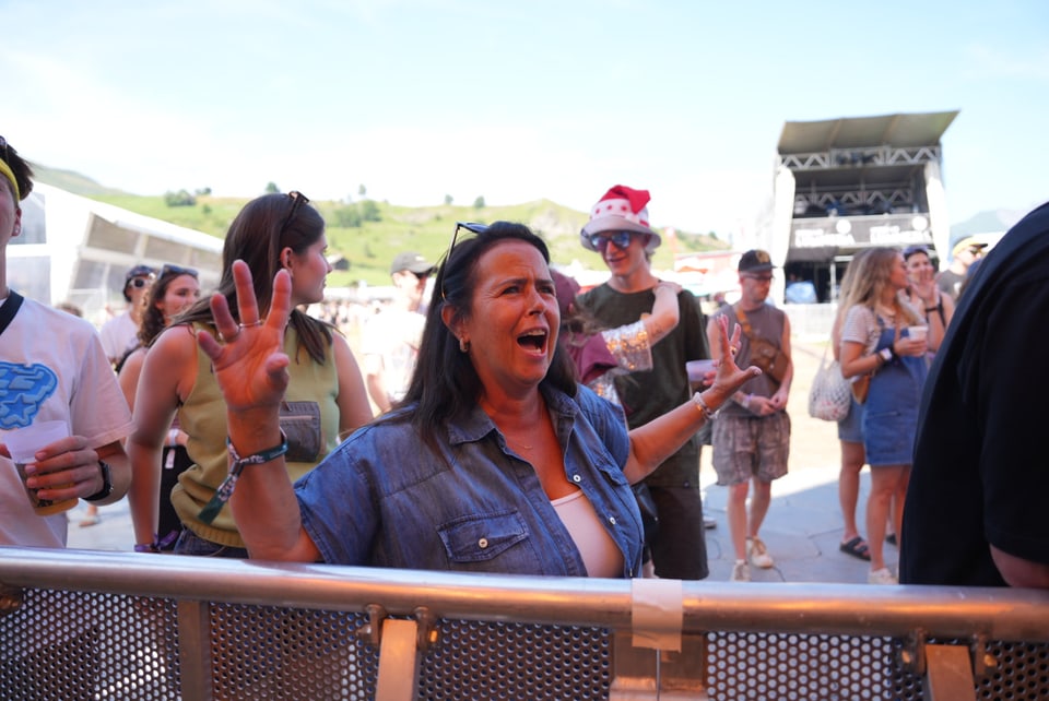 Frau feiert auf einem Musikfestival im Freien am Open Air Lumnezia 2024 in Degen..