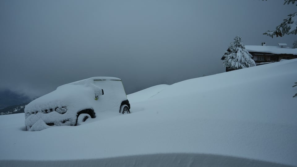 Ein Auto steckt im Schnee fest.