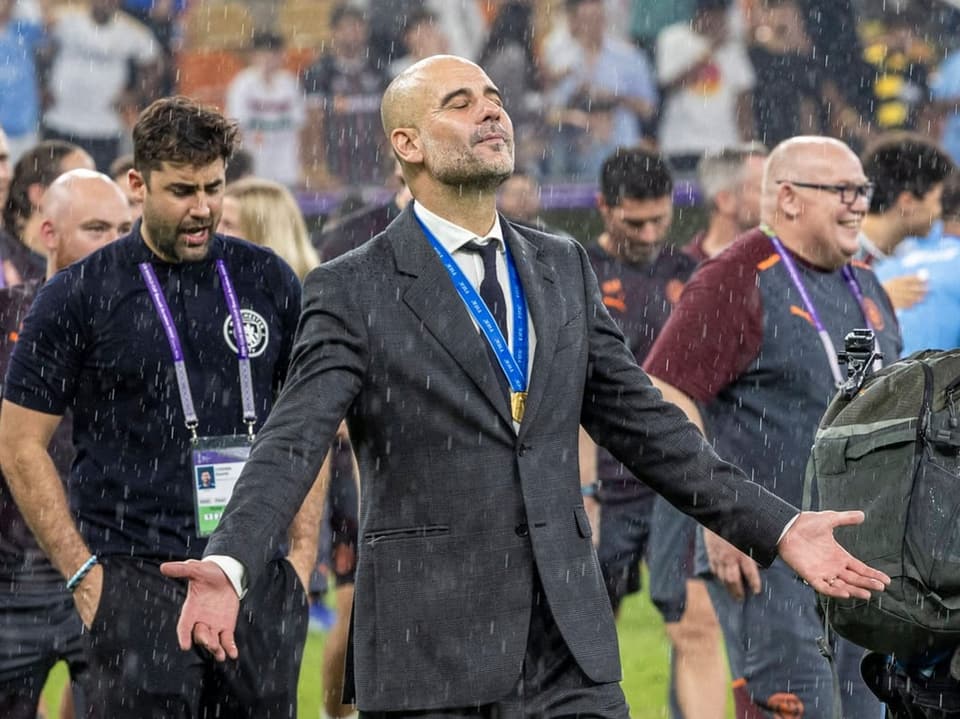 Pep Guardiola steht glücklich im Regen.