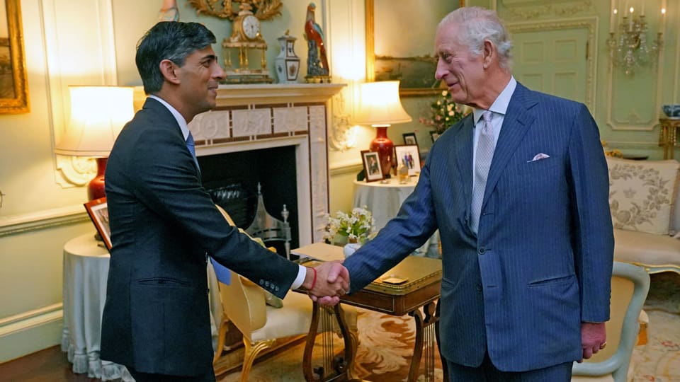 König Charles und Premierminister Rishi Sunak schütteln sich bei einem Treffen im Buckingham Palace die Hand.