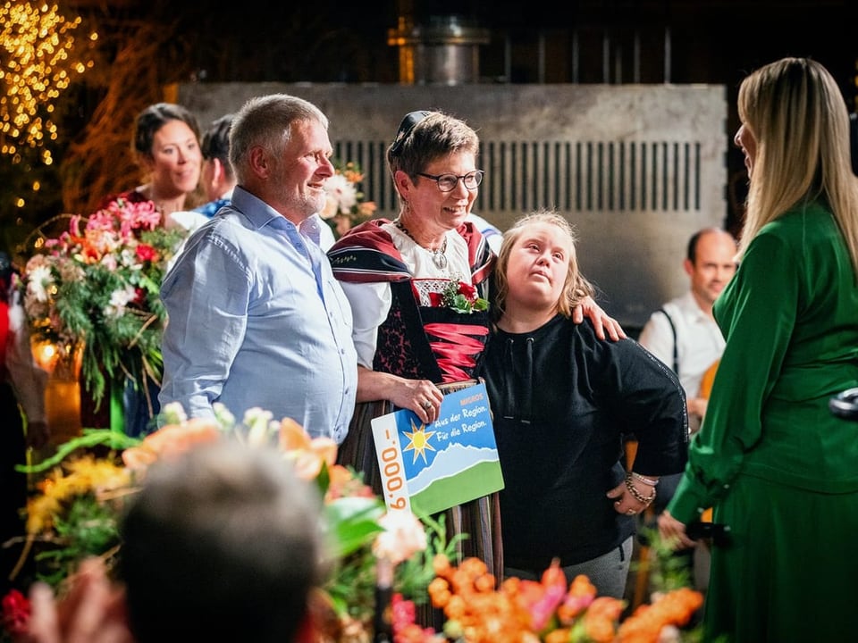 Eine Familie posiert für ein Bild, Blumen im Vordergrund und Hintergrund.