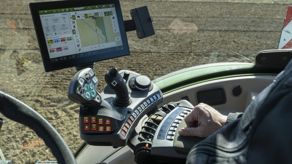 Ein Traktor aus Fahrersicht mit viel Technologie