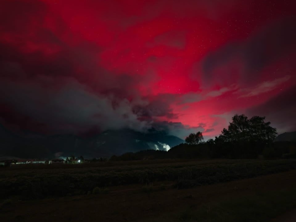 Dramatischer roter Himmel über Landschaft bei Nacht.