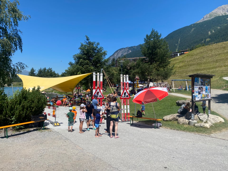 Survista da la festa d'uffants. Famiglias cun uffants davant ina tenda.