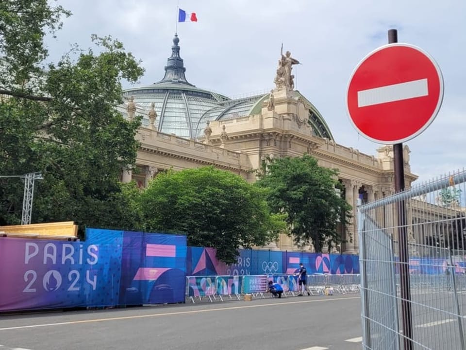 Blick auf das Grand Palais in Paris mit Paris 2024-Bannern und einem Einbahnstrassenschild.