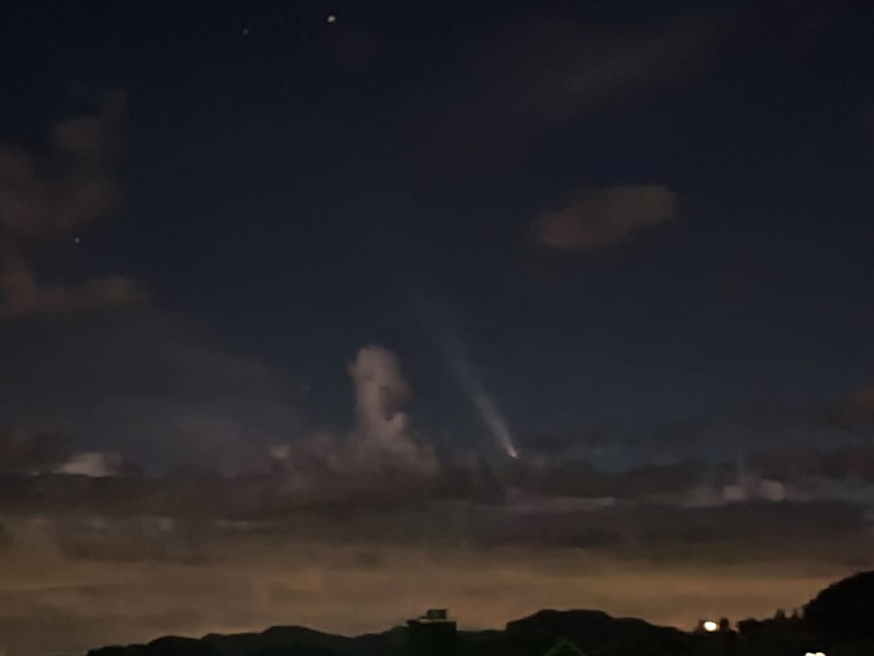 Nachthimmel mit Komet über Wolken.