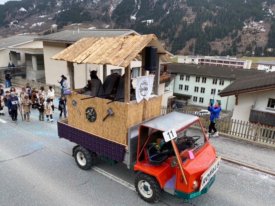 Verkleidete Vikinger fahren auf einem landwirtschaftlichen Fahrzeug am Fasnachtsumzug in Disentis mit.