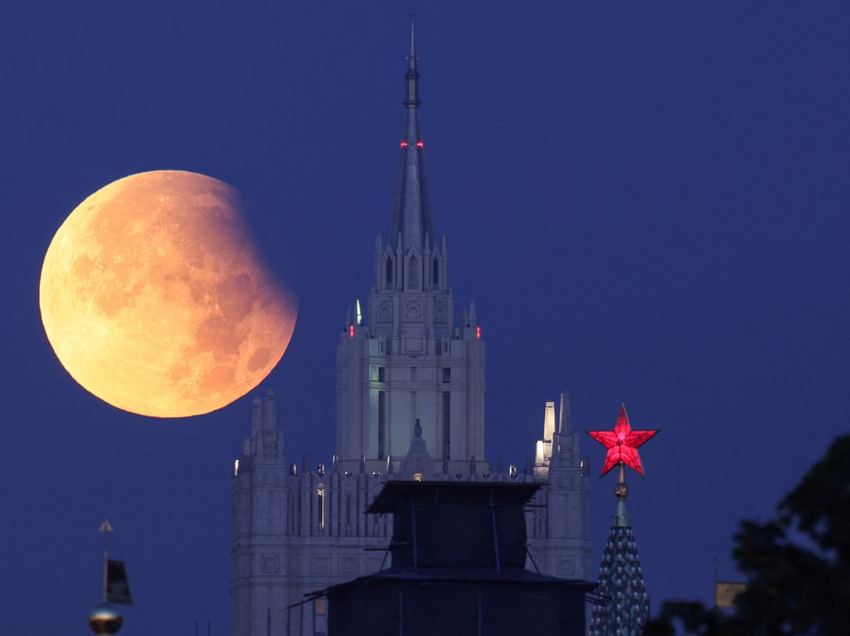 Mondfinsternis hinter einem gotischen Gebäude und rotem Stern.