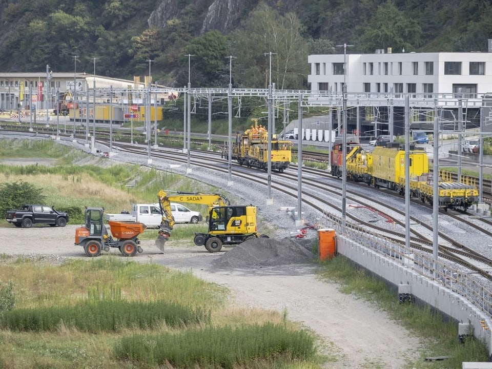 Baustelle an Eisenbahnstrecke mit Bagger und Bauarbeiter".