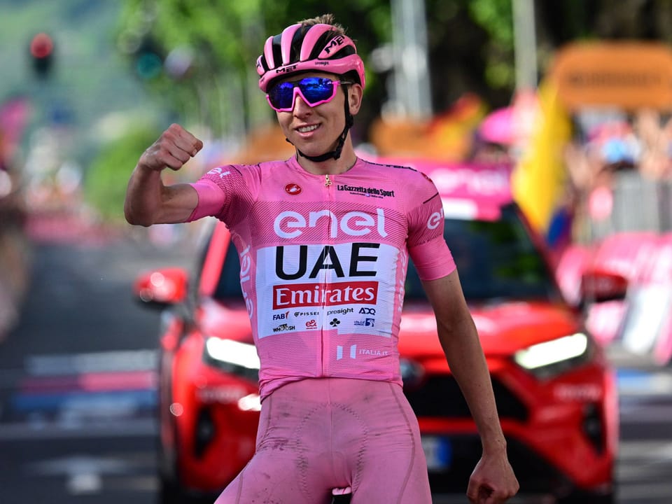 Radrennfahrer im rosa Trikot feiert vor dem Start eines Rennens.
