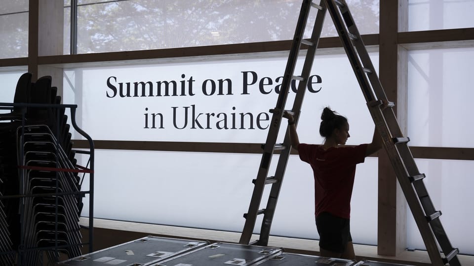 Eine Leiter zur Montage steht neben einer grossen Schrift: Summit on Peace in Ukraine