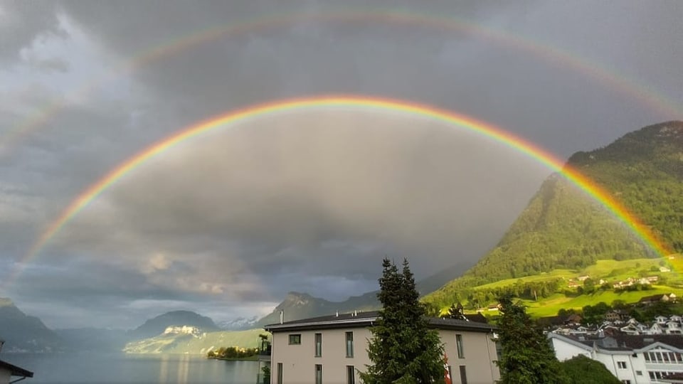 Doppelregenbogen über See und Bergen.
