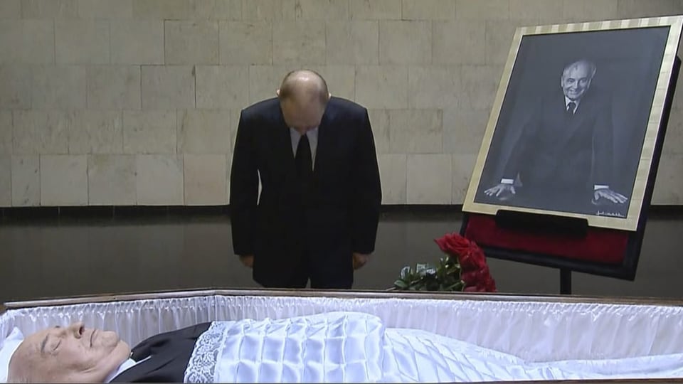 Putin bows to open coffin