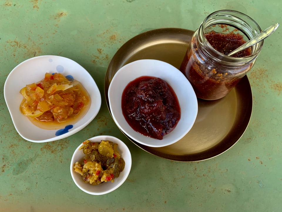 Verschiedene Chutneys auf Tellern und in einem Glas.